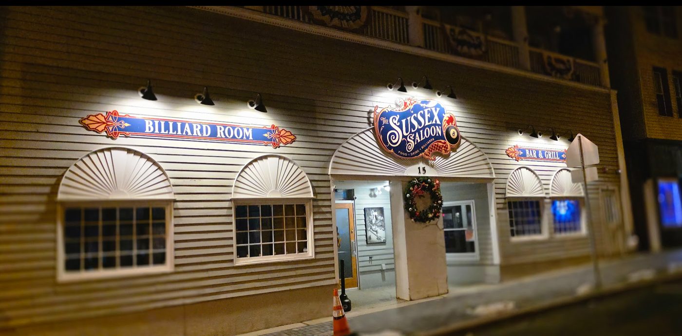 The Sussex Saloon storefront glowing at night